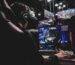 Gamer foran flere skærme i mørkt setup – illustrerer brug af gaming gear